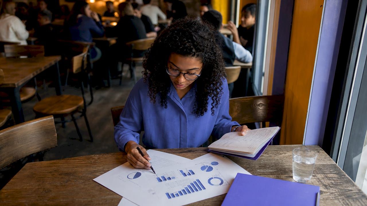 Une jeune femme analyse les performances du marché immobilier local pour évaluer sa rentabilité.