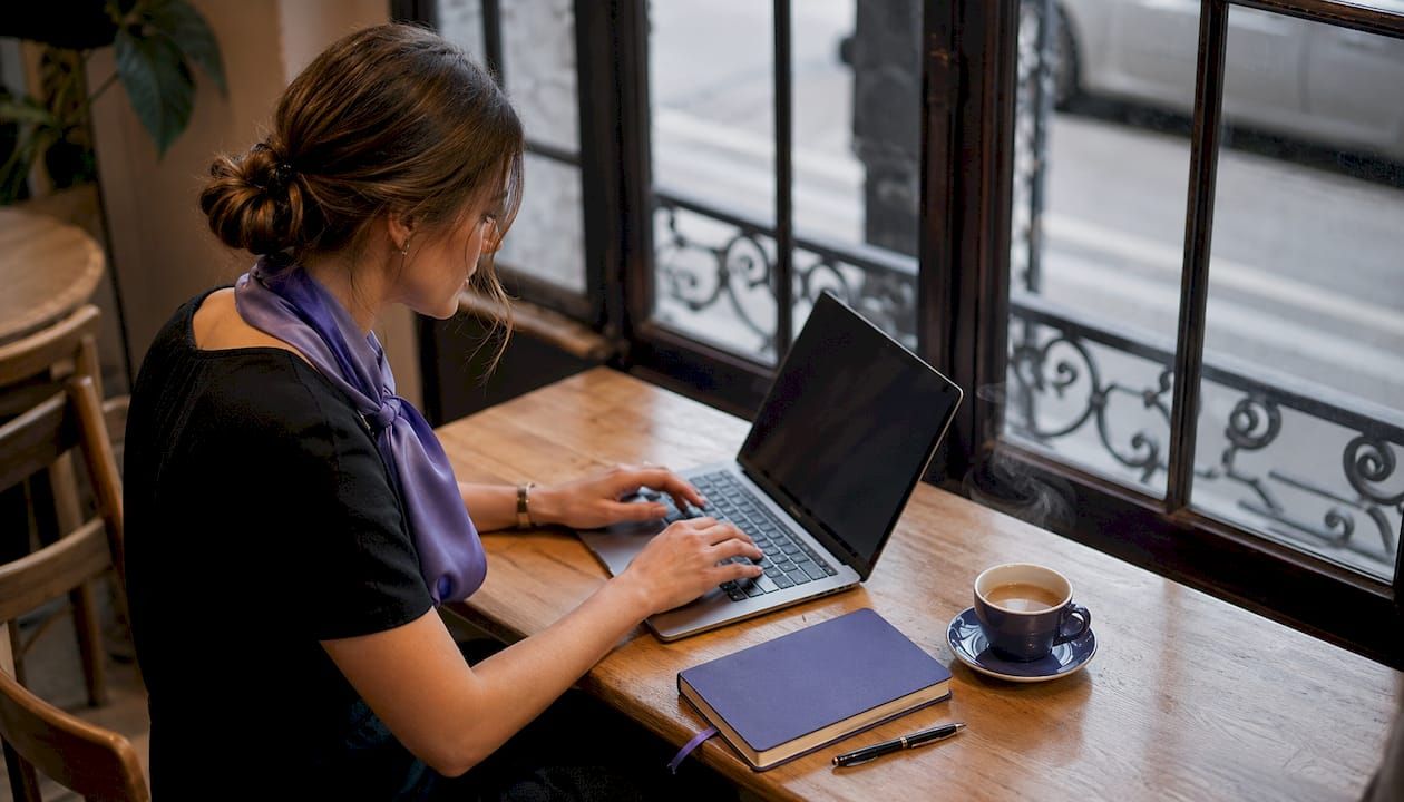 Des mains s’activent sur le clavier d’un ordinateur, en pleine séance de travail au bureau.