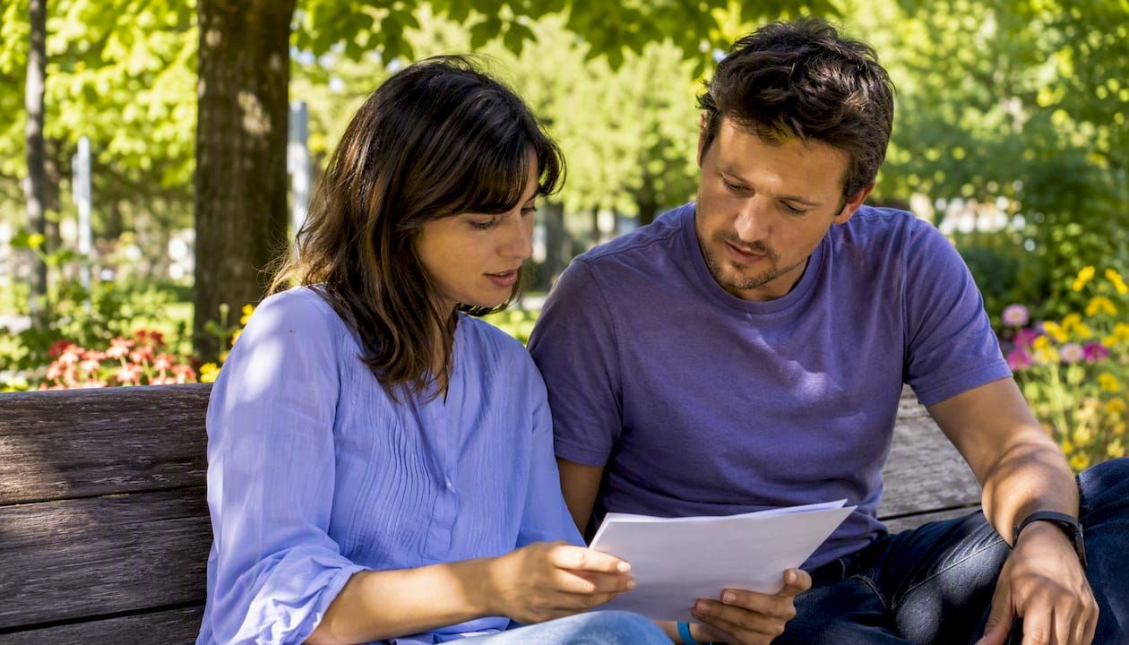 Un couple en train de vérifier ensemble leur formulaire d'autorisation de prélèvement SEPA.